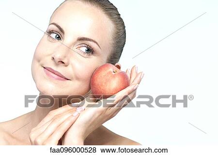 Stock Photo - Young woman with peach. Fotosearch