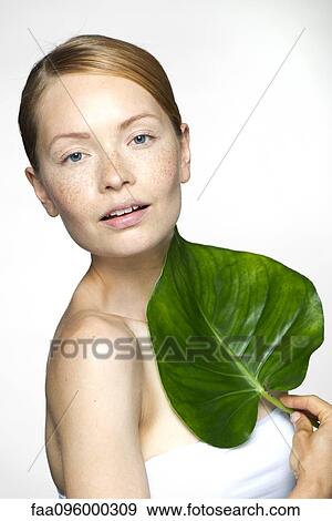 Young woman with tropical plant leaf, portrait View Large Photo Image Stock Photo - Young woman with tropical plant leaf, portrait. Fotosearch