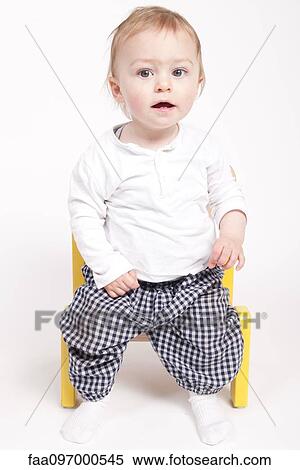 Stock Photography - Baby boy sitting in chair, studio portrait. Fotosearch