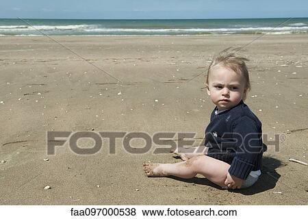 Stock Photo - Baby sitting on beach. Fotosearch