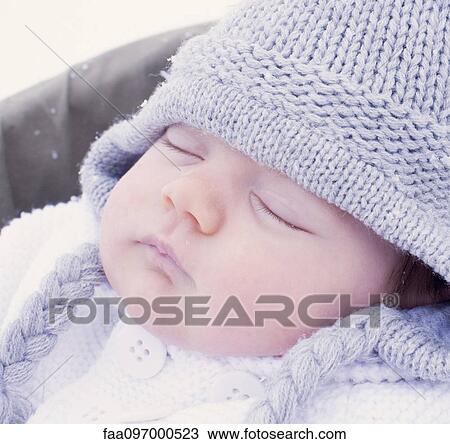 Stock Image - Baby sleeping, wearing knit hat, portrait. Fotosearch