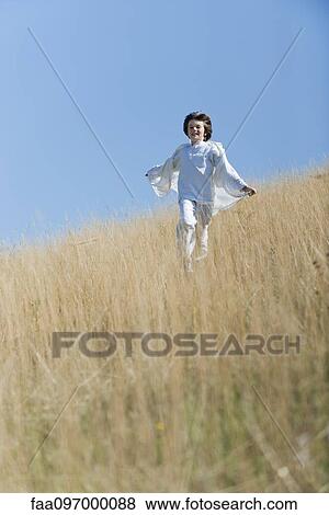 Stock Photo - Boy running through tall grass. Fotosearch