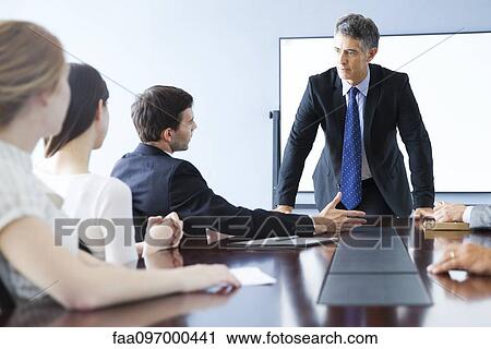 Stock Image - Business associates discuss matter during meeting. Fotosearch