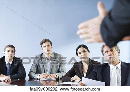 Business associates listen as colleague makes presentation during meeting View Large Photo Image Stock Image - Business associates listen as colleague makes presentation during meeting. Fotosearch