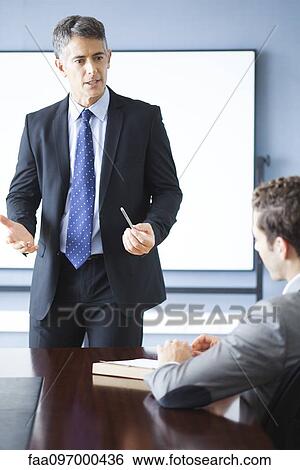 Business executive giving presentation at meeting View Large Photo Image Stock Photograph - Business executive giving presentation at meeting. Fotosearch