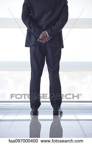 Businessman looking out high rise window at view of city below, rear view View Large Photo Image Stock Image - Businessman looking out high rise window at view of city below, rear view. Fotosearch