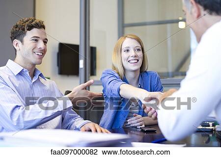 Stock Image - Businessman shaking hands with client in meeting. Fotosearch