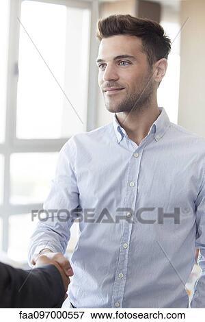 Businessman shaking hands with colleague, cropped View Large Photo Image Stock Photo - Businessman shaking hands with colleague, cropped. Fotosearch