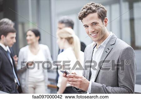 Businessman using cell phone while on the move View Large Photo Image Stock Image - Businessman using cell phone while on the move. Fotosearch