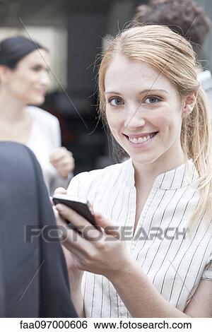 Businesswoman checking smartphone on the move View Large Photo Image Stock Photograph - Businesswoman checking smartphone on the move. Fotosearch