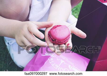 Stock Photo - Child eating macaroon. Fotosearch