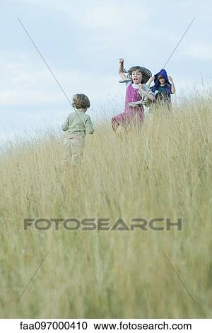 Children playing in tall grass on hillside View Large Photo Image Stock Image - Children playing in tall grass on hillside. Fotosearch