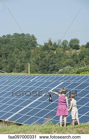 Children standing together in front of solar panels, girl holding old-fashioned latern View Large Photo Image Stock Image - Children standing together in front of solar panels, girl holding old-fashioned latern. Fotosearch