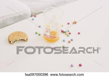 Child's sweets scattered on table by glass of juice View Large Photo Image Stock Photograph - Child's sweets scattered on table by glass of juice. Fotosearch