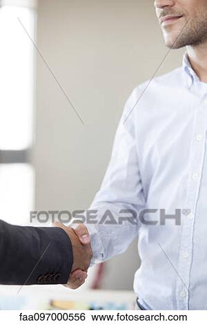 Stock Photograph - Client shaking hands with businessman. Fotosearch