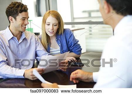 Clients going over paperwork with consultant View Large Photo Image Stock Image - Clients going over paperwork with consultant. Fotosearch