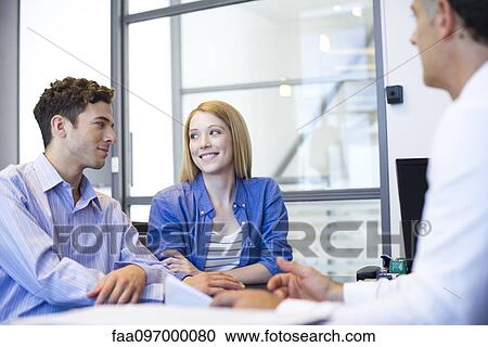 Stock Image - Clients meeting with advisor in office. Fotosearch