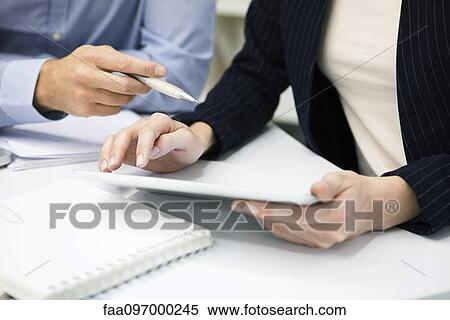 Colleagues using digital tablet, cropped View Large Photo Image Stock Photography - Colleagues using digital tablet, cropped. Fotosearch