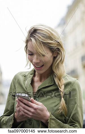 Stock Photography - Communicating through social media on smartphone while on the go. Fotosearch