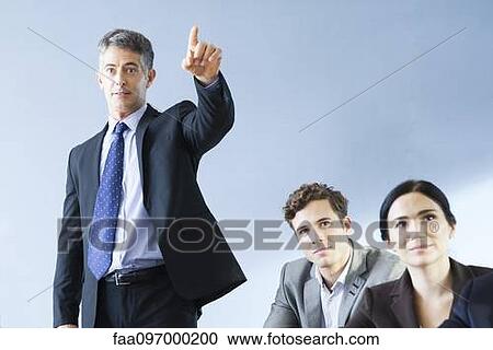 Stock Image - Corporate trainer leading training session. Fotosearch
