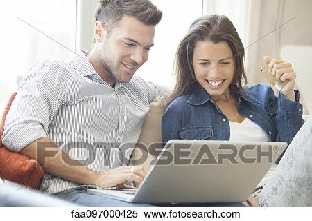 Stock Photography - Couple at home shopping online together. Fotosearch