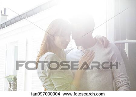 Couple embracing by open window View Large Photo Image Picture - Couple embracing by open window. Fotosearch