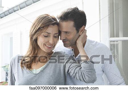 Couple embracing by open window View Large Photo Image Stock Photograph - Couple embracing by open window. Fotosearch