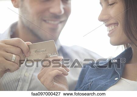 Couple preparing to make credit card purchase View Large Photo Image Stock Photo - Couple preparing to make credit card purchase. Fotosearch