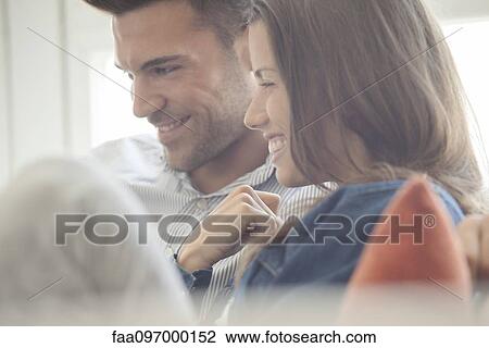 Couple relaxing at home looking at laptop computer together View Large Photo Image Stock Image - Couple relaxing at home looking at laptop computer together. Fotosearch