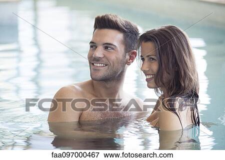 Stock Photo - Couple relaxing together in pool. Fotosearch