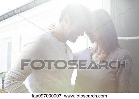 Couple touching heads, smiling View Large Photo Image Stock Photo - Couple touching heads, smiling. Fotosearch