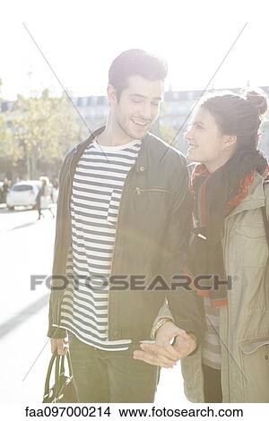Picture - Couple walking in city holding hands. Fotosearch