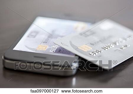 Credit card resting on smartphone View Large Photo Image Stock Photo - Credit card resting on smartphone. Fotosearch
