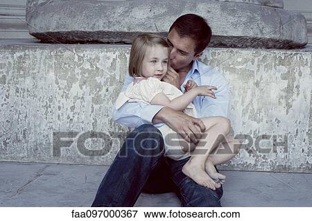 Stock Photo - Father holding young daughter on his lap. Fotosearch