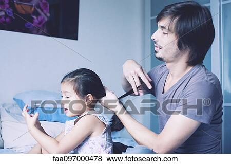 Father putting daughter's hair in ponytail View Large Photo Image Stock Photo - Father putting daughter's hair in ponytail. Fotosearch