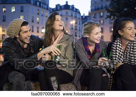 Stock Photography - Friends having beers together outdoors. Fotosearch