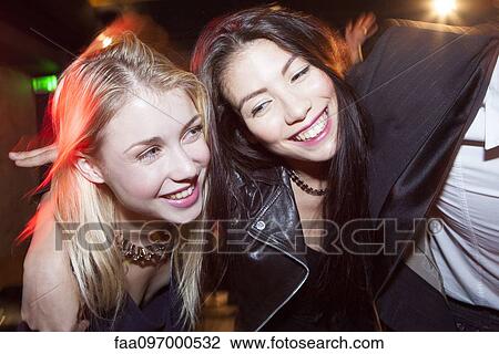 Stock Image - Friends out at night having fun. Fotosearch