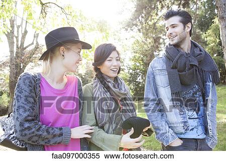 Friends walking together in park View Large Photo Image Stock Photography - Friends walking together in park. Fotosearch