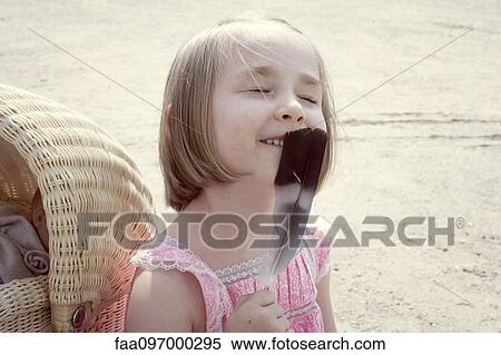 Little girl holding feather up to face, eyes closed, portrait View Large Photo Image Stock Photography - Little girl holding feather up to face, eyes closed, portrait. Fotosearch