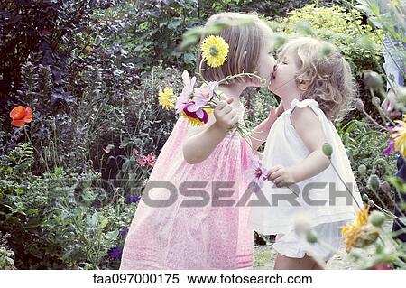 Little girl kissing her baby sister outdoors View Large Photo Image Stock Photography - Little girl kissing her baby sister outdoors. Fotosearch