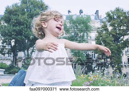 Little girl playing outdoors View Large Photo Image Stock Image - Little girl playing outdoors. Fotosearch