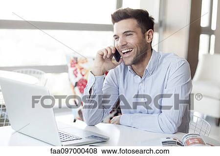 Stock Photo - Man making cell phone call at home. Fotosearch