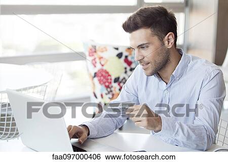 Man preparing to make online purchase using credit card View Large Photo Image Stock Photograph - Man preparing to make online purchase using credit card. Fotosearch