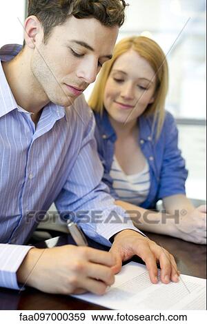 Man signing paperwork in office View Large Photo Image Stock Photo - Man signing paperwork in office. Fotosearch