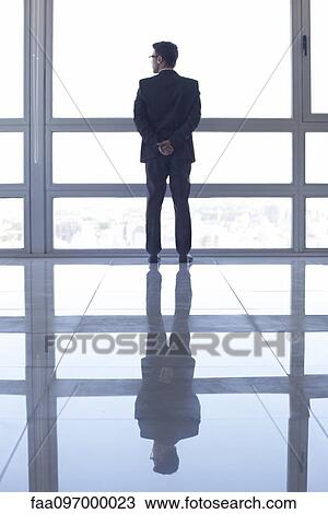 Man standing in front of window, looking at view View Large Photo Image Stock Image - Man standing in front of window, looking at view. Fotosearch