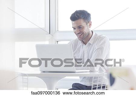 Stock Photograph - Man using laptop computer. Fotosearch