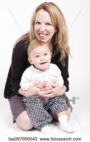 Mother holding baby boy on lap, studio portrait View Large Photo Image Stock Image - Mother holding baby boy on lap, studio portrait. Fotosearch