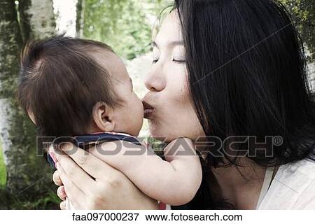 Mother kissing infant son View Large Photo Image Stock Photo - Mother kissing infant son. Fotosearch