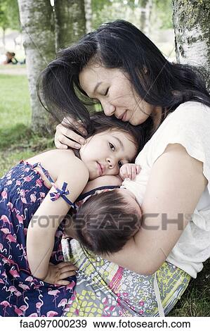 Stock Photo - Mother with baby and little girl outdoors. Fotosearch