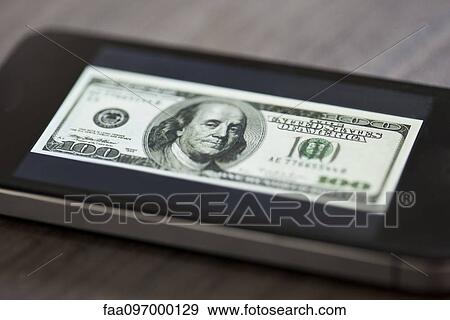 Smartphone displaying image of one-hundred dollar bill View Large Photo Image Stock Photo - Smartphone displaying image of one-hundred dollar bill. Fotosearch